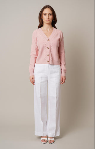 Model is wearing the cable knit button front cardigan by Cyrus in Rose Petal