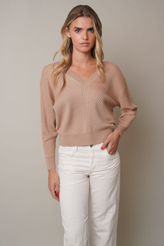 Model is wearing the V-Neck Ribbed Dolman Sweaterby Cyrus in Toffee