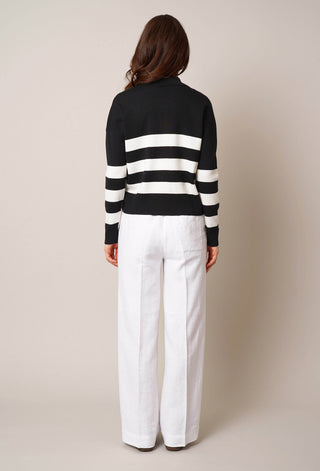 Model is wearing the striped split neck pullover by Cyrus in Black/Cream