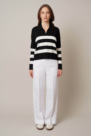 Model is wearing the striped split neck pullover by Cyrus in Black/Cream