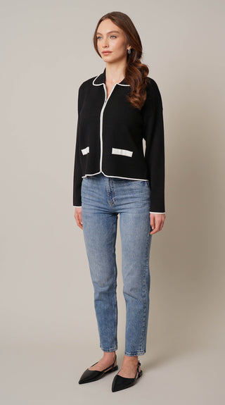 Model is wearing the zip up cardigan with tipping by Cyrus in Black/Bone