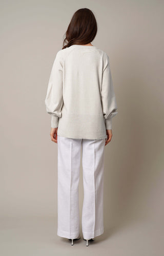 Model is wearing the crew neck pullover with side slit by Cyrus in Cream