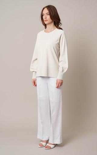 Model is wearing the crew neck pullover with side slit by Cyrus in Cream