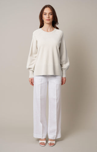 Model is wearing the crew neck pullover with side slit by Cyrus in Cream