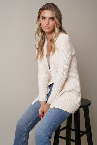 Model is wearing the Long Sleeve Cabled Cardiganby Cyrus in Cream