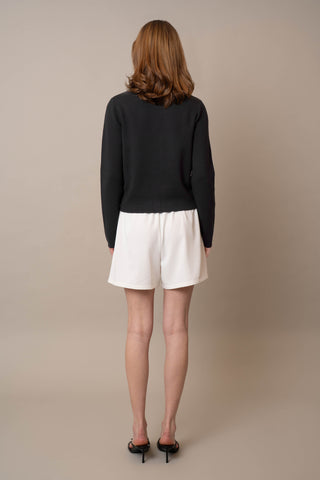 Model is wearing the Crew Neck Button Down Cardigan by Cyrus in Black