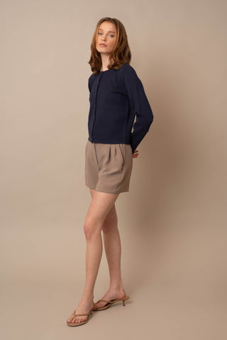 Model is wearing the Crew Neck Button Down Cardigan by Cyrus in Eclipse