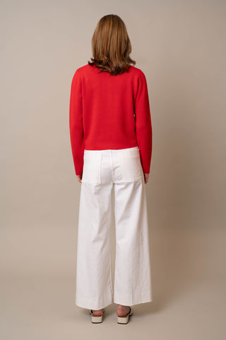Model is wearing the Crew Neck Button Down Cardigan by Cyrus in Flame Scarlett