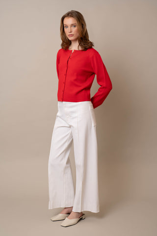 Model is wearing the Crew Neck Button Down Cardigan by Cyrus in Flame Scarlett
