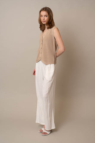 Model is wearing the Button Front V-Neck Vest by Cyrus in Irish Cream