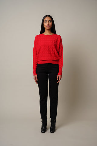 Model is wearing the Cable Knit Dolman Pullover in Cabernet Red.