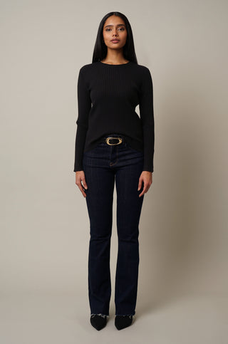 Model is wearing the Crew Neck Ribbed Pullover in Black.