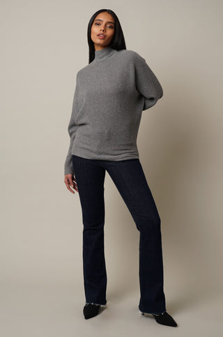 Model is wearing the Mock Neck Dolman Pullover in Medium Heather Grey.