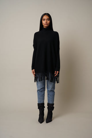 Model is wearing the Turtle Neck Dolman with Fringes in Black.