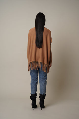 Model is wearing the Turtle Neck Dolman with Fringes in Tan.