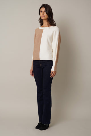 The model is wearing a white and beige Cyrus Color Block Dolman Sweater.