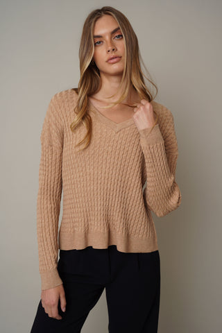 A model wearing the v-neck cable knit pullover by cyrus in toffee