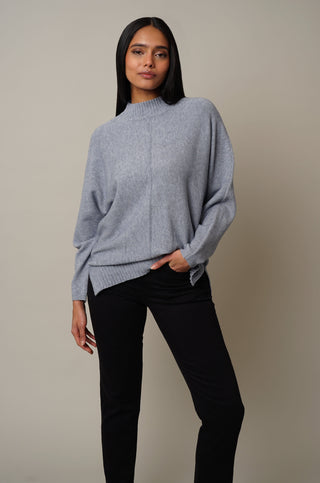 Model is wearing the Dolman Sleeve Mock Neck Pullover in Lily Blue.