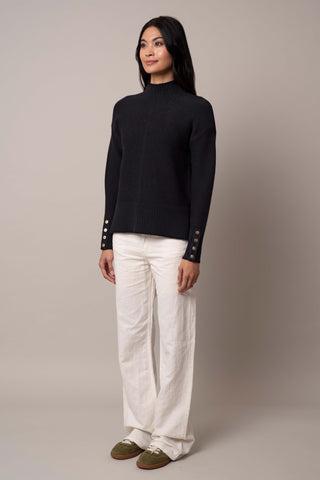 Model is wearing the mock-neck-pullover-with-button-cuff in Black