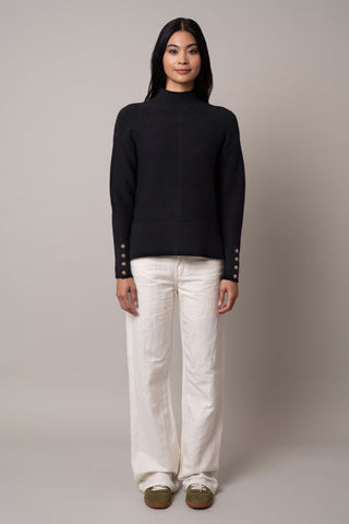 Model is wearing the mock-neck-pullover-with-button-cuff in Black