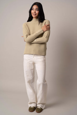 Model is wearing the mock-neck-pullover-with-button-cuff in Pale Olive