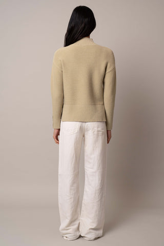 Model is wearing the mock-neck-pullover-with-button-cuff in Pale Olive