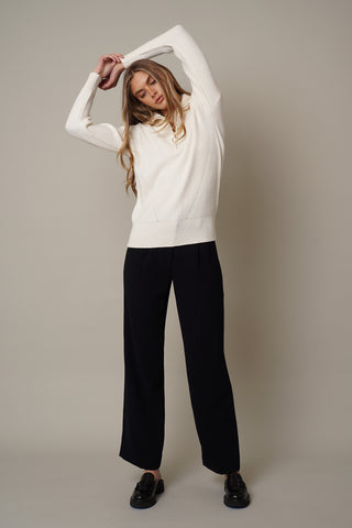 A model wearing a half zip sweater by Cyrus in cream.