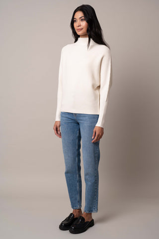 Model is wearing the funnel-neck-sweater-with-ribbed-cuff in Cream