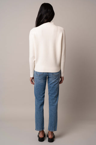 Model is wearing the funnel-neck-sweater-with-ribbed-cuff in Cream