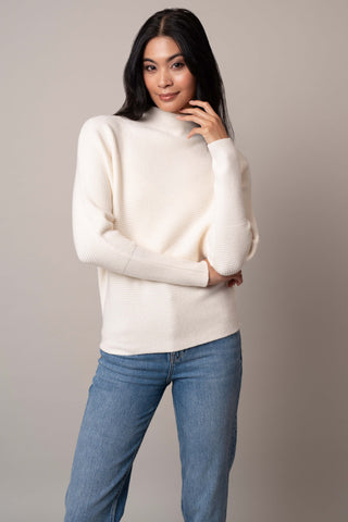 Model is wearing the funnel-neck-sweater-with-ribbed-cuff in Cream