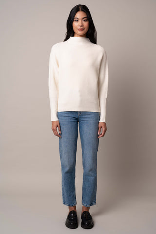 Model is wearing the funnel-neck-sweater-with-ribbed-cuff in Cream