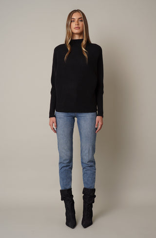 model is wearing a funnel neck sweater with ribbed cuff by cyrus in black