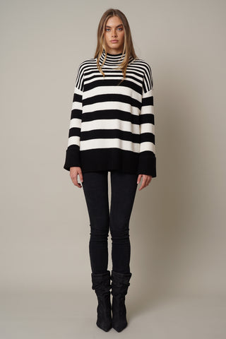 A model wearing the mock neck striped sweater by Cyrus in black and cream.