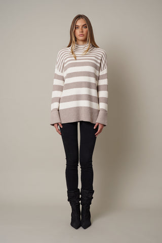 A model wearing the mock neck striped sweater by Cyrus in kitten heather and cream.