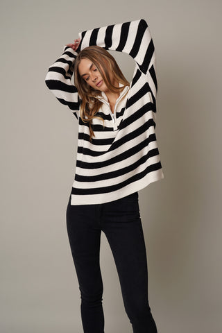 A model wearing a half zip striped sweater by Cyrus in cream and black.