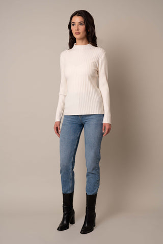 Model is wearing the Mock Neck Ribbed Pullover in Cream.