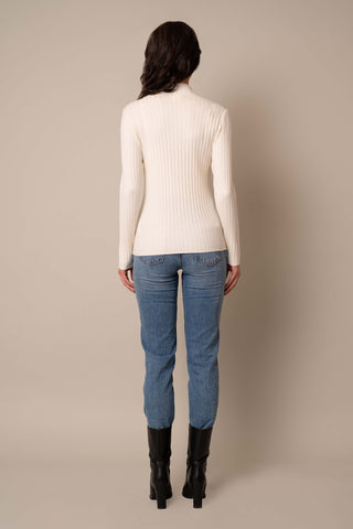 Model is wearing the Mock Neck Ribbed Pullover in Cream.