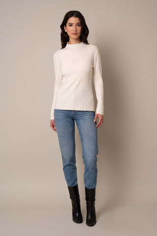 Model is wearing the Mock Neck Ribbed Pullover in Cream.