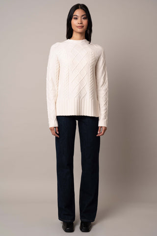 Model is wearing the cable-funnel-neck-pullover in Cream