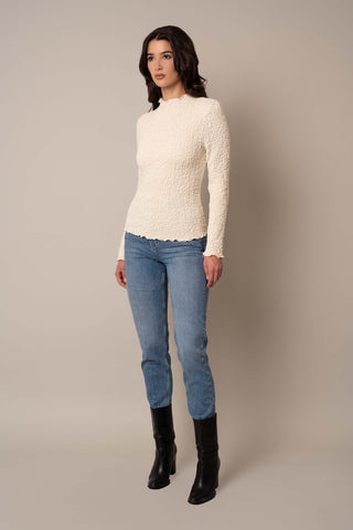 Model is wearing the Long Sleeve Mock Neck Crinkle Top in Cream.