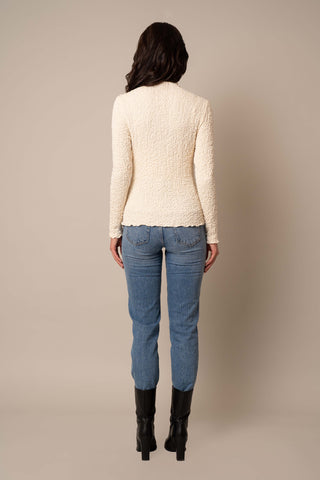 Model is wearing the Long Sleeve Mock Neck Crinkle Top in Cream.