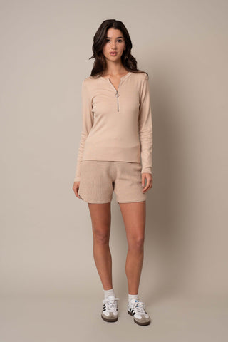 Model is wearing the Ribbed Half Zip Top in Oatmeal Cookie.