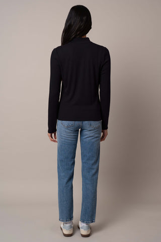 Model is wearing the Ribbed Mock Neck Zip-Up in Black.