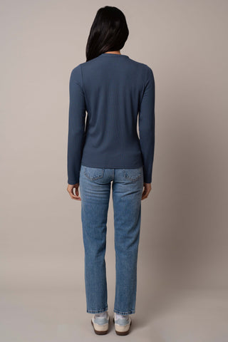 Model is wearing the Ribbed Mock Neck Zip-Up in Blue Depth.